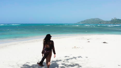 aerial reveal of solo traveler exploring white sand beaches of playa teco maimon outside of puerto plata, dominican republic