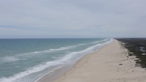 total view tracking shot, drone flight over the waves at the australian coastline, waves crash on the beach, no people, daylight