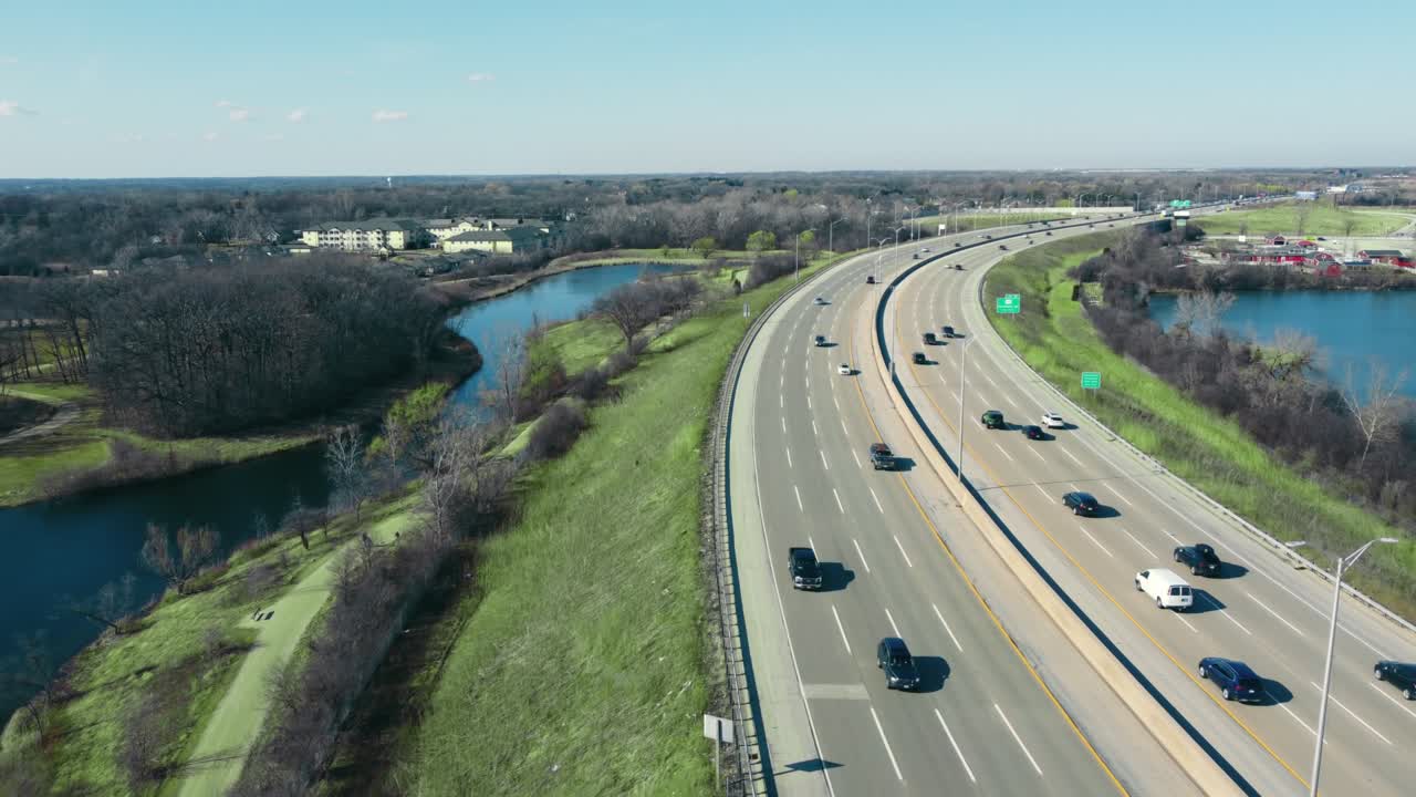 Flight over the highway and car traffic moving in the direction of the big city. Large highway with heavy traffic.