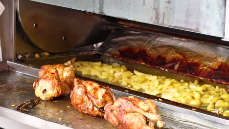 chicken and potatoes roasting in a rotisserie oven