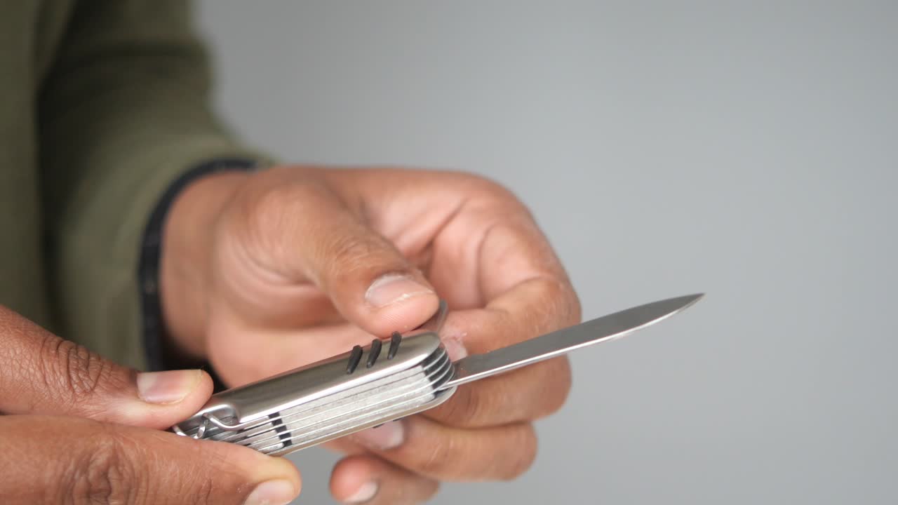Man's hands holding a multi-tool pocket knife