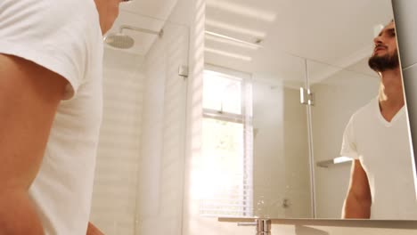 man washing his face with a towel in bathroom