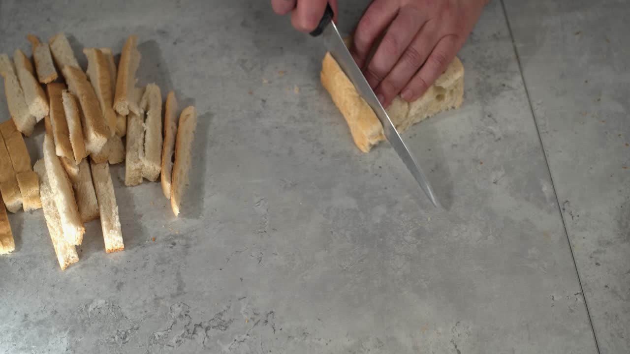 las costras se cortan rebanadas de pan en una encimera de mármol con espacio para copiar