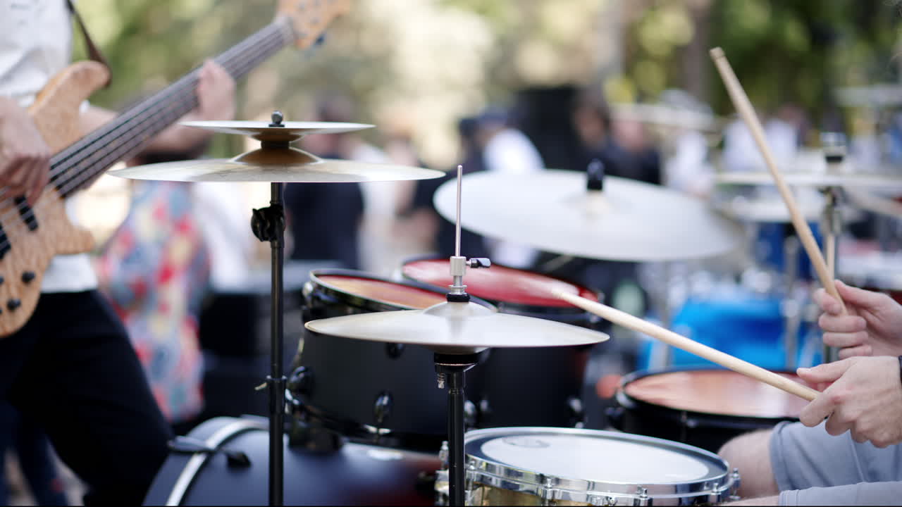 Close up of man playing the drums with a band outside