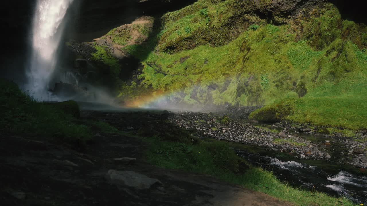 hombre tocando la guitarra frente a una hermosa cascada en islandia-17