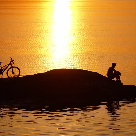 male cyclist resting near river