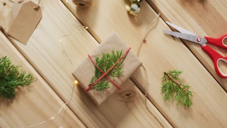 video of christmas decorations with present and scissors on wooden background