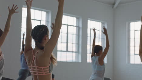 yoga class of healthy women practicing crescent lunge pose in fitness studio at sunrise enjoying early morning exercise