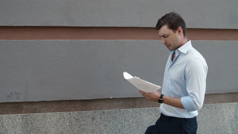 closeup businessman reading papers outdoor. man throwing documents at street