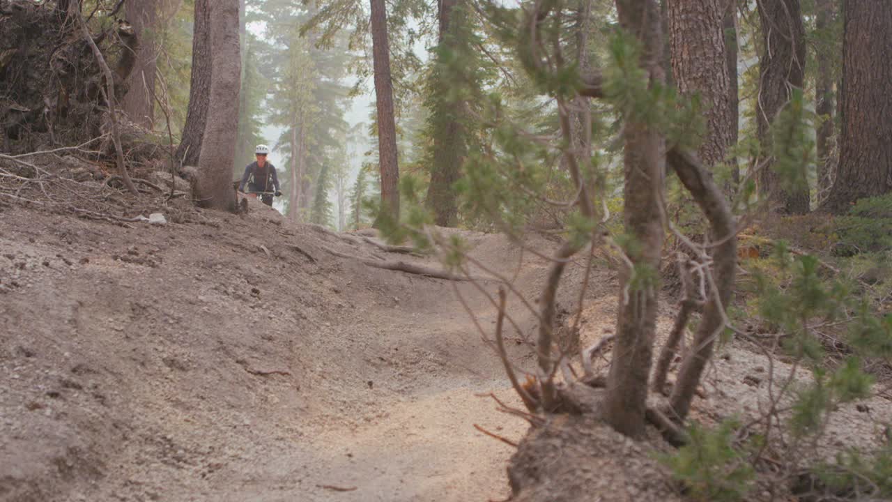 un ciclista de montaña recorre un camino de tierra en un bosque