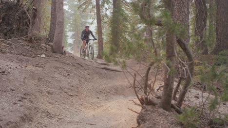 un ciclista de montaña recorre un camino de tierra en un bosque