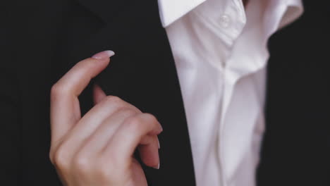 woman hand near man wearing black jacket and white shirt