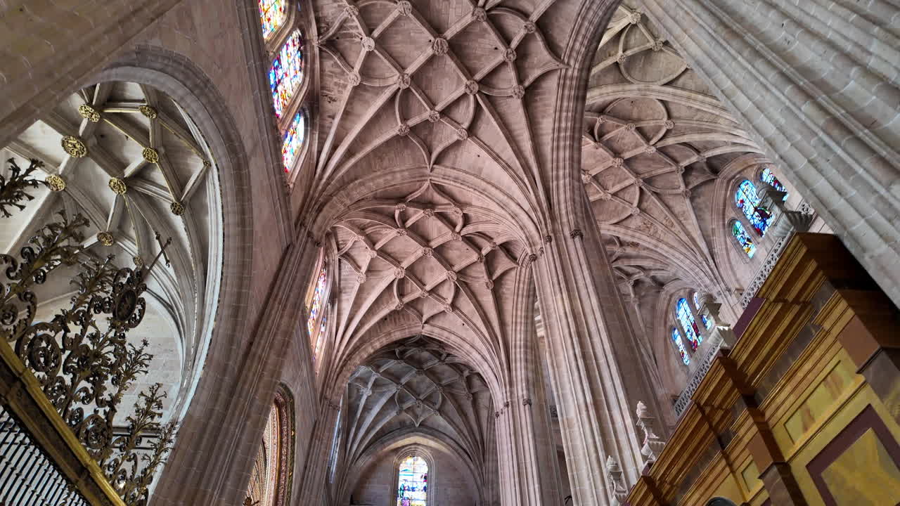 Movimiento lento dentro de la Catedral de Segovia que destaca la arquitectura gótica del techo, las columnas y las vidrieras