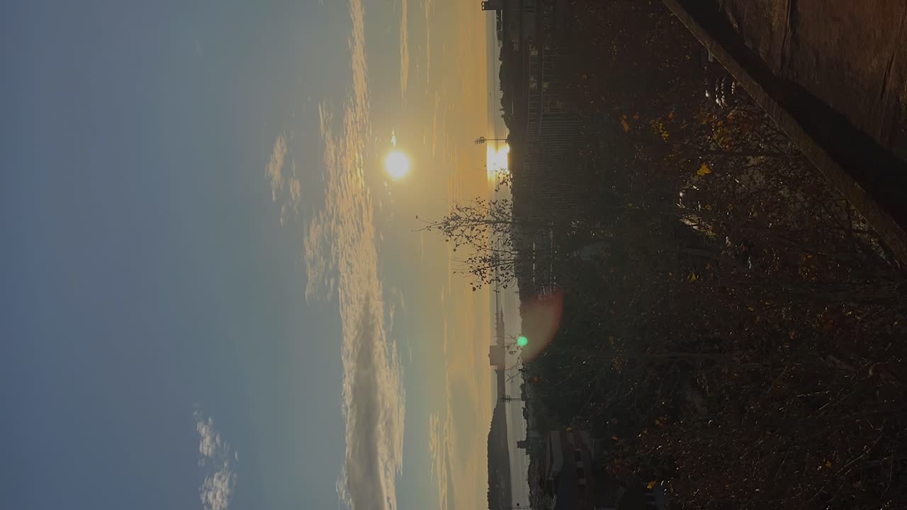 Vertical time-lapse video of a sunset over the river and bay of Lisbon, Portugal. Captures the serene beauty of the sky's transformation and reflections on the water, embodying a peaceful.