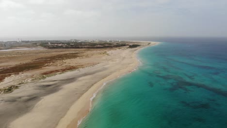 Aerial-View-Over-Beautiful-Blue-Turquoise-Ocean-Waters-Beside-Idyllic-Beach