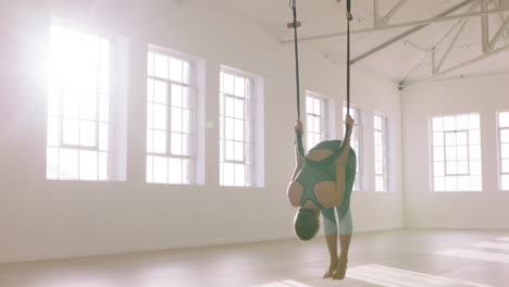 Aerial-Yoga-Frau-übt-Stehende-Gebetshaltung-In-Der-Hängematte-Und-Genießt-Einen-Gesunden-Fitness-Lebensstil,-Indem-Sie-Im-Studio-Trainiert-Und-Bei-Sonnenaufgang-Meditation-Trainiert