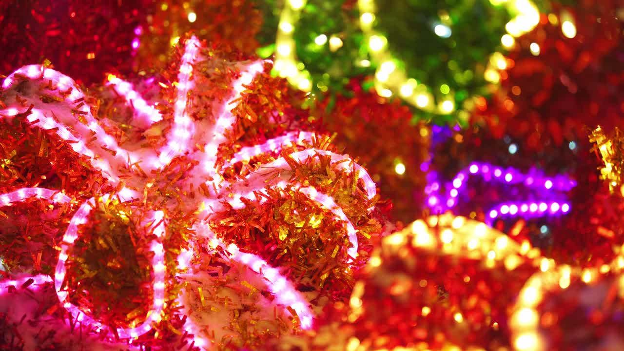 colorida y brillante decoración navideña. decoración reluciente de neón brillante en la calle de cerca. feliz año nuevo. celebración de las vacaciones de invierno en la ciudad nocturna. imágenes en 4k