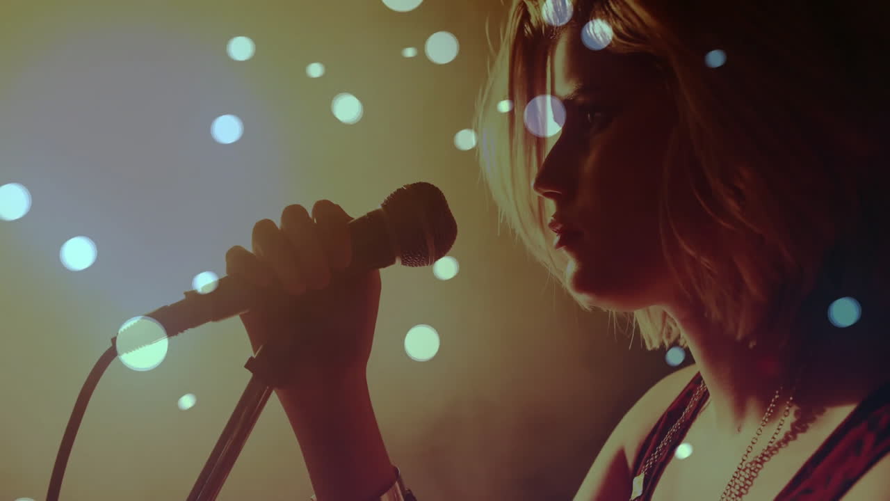 female singer holding microphone on music stage, displaying animated bokeh light orbs