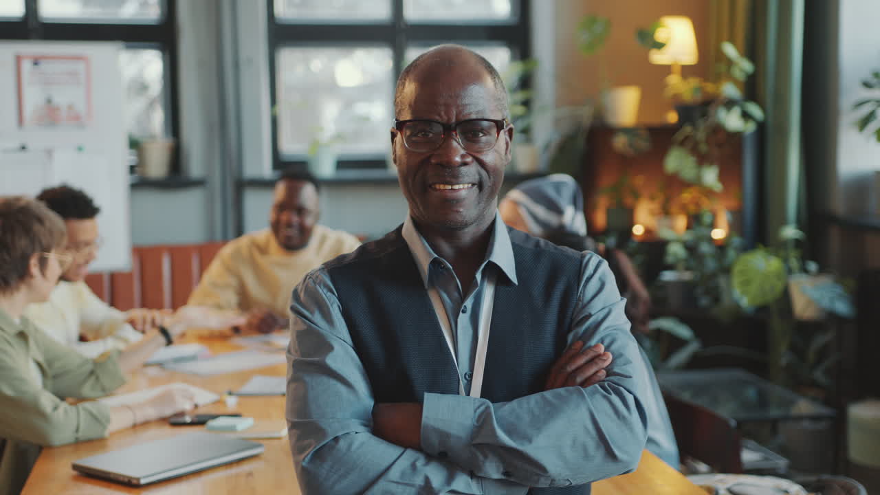 Portrait of Senior Black Teacher Posing with a Smile in Classroom
