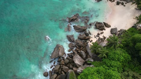 Bird-eye-drone-shot-of-hidden-beach-near-north-east-point-beach,-huge-rock-boulders,-white-sandy-beach-and-turquoise-water,-Mahe-seychelles-30fps-3