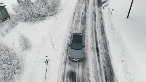 Drohnenaufnahmen-Von-Einem-Auto,-Das-Auf-Einer-Winterlichen-Waldstraße-Fährt