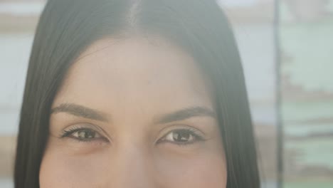 Retrato-De-Cerca-De-Los-Ojos-De-Una-Mujer-Hispana-Sonriente-Bajo-El-Sol,-Cámara-Lenta