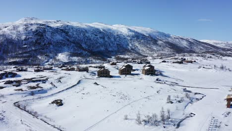 maurset hardangervidda norwegen – luftaufnahme von ferienhäusern zwischen schneebedeckten bergen in der nähe von rv7