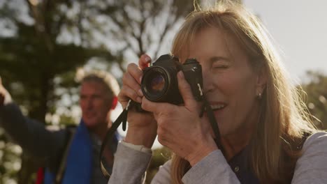 active senior woman taking picture in forest