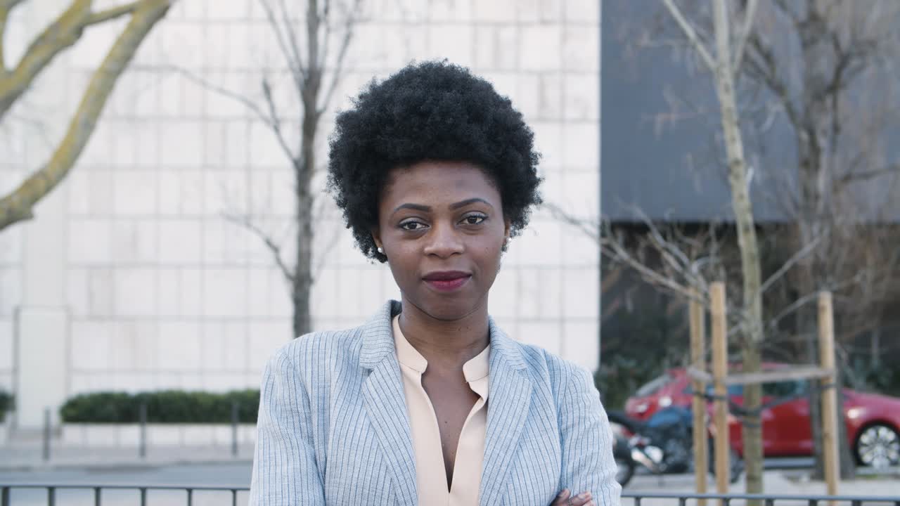 hermosa mujer afroamericana sonriente con los brazos cruzados