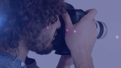 spot of light against african american male photographer clicking pictures with digital camera