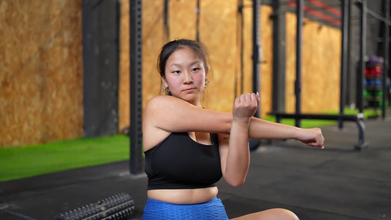 mujer estirándose en el gimnasio