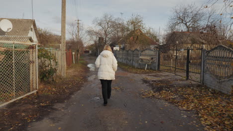 woman walking down a rural path in autumn