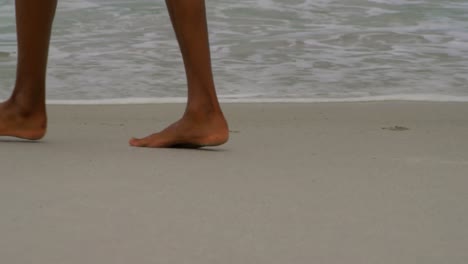 low section of man walking barefoot at beach on a sunny day 4k