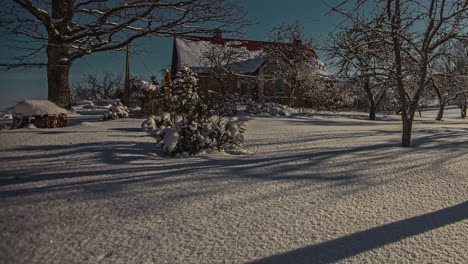 Hermosa-Línea-De-Tiempo-De-La-Sombra-De-La-Luz-Del-Sol-Moviéndose-A-Través-Del-Patio-Delantero-Vacío-Cubierto-De-Nieve-Fresca-De-La-Casa-De-Vacaciones-De-Madera,-Tiro-De-ángulo-Bajo-Y-Ancho