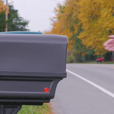 un hombre pone correo en un buzón 1