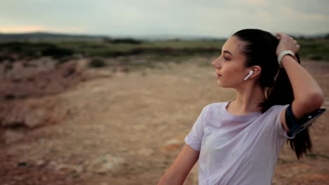 female runner listening to music and looking at sea view