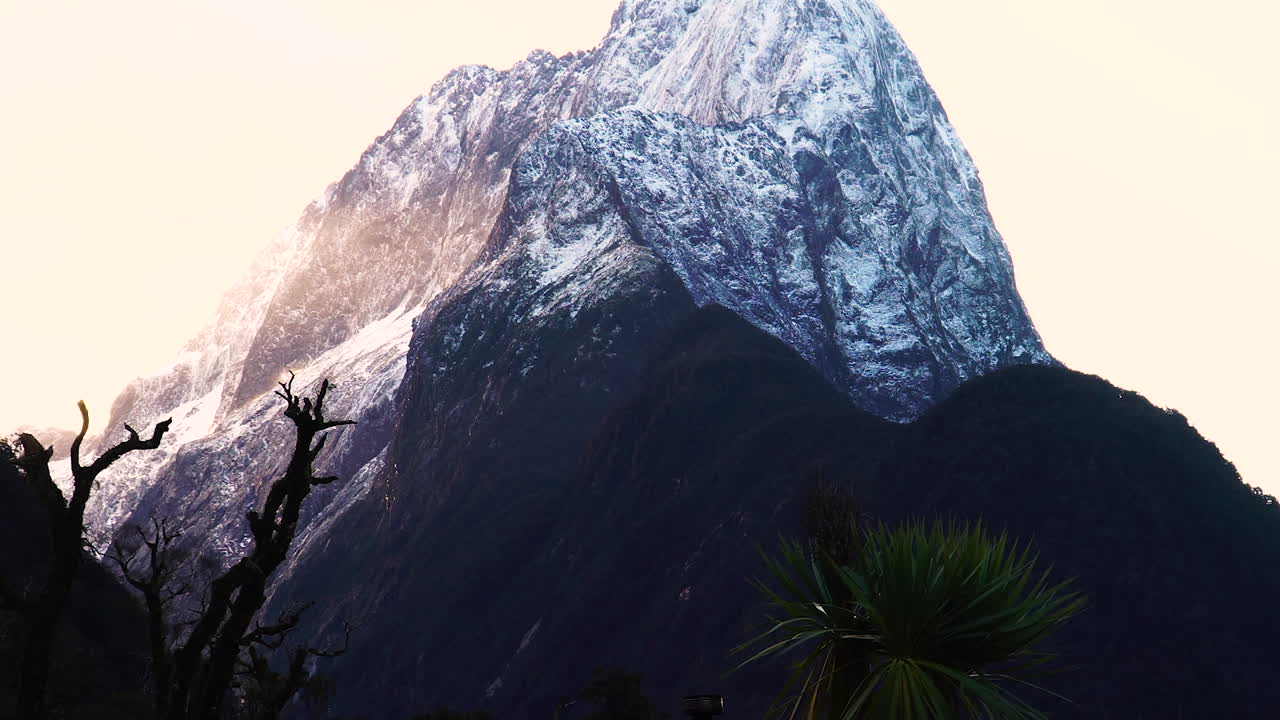 Ripresa dal basso verso l'alto che rivela la cima innevata e scoscesa del maestoso Monte Pembroke vicino a Milford Sound in Nuova Zelanda.
