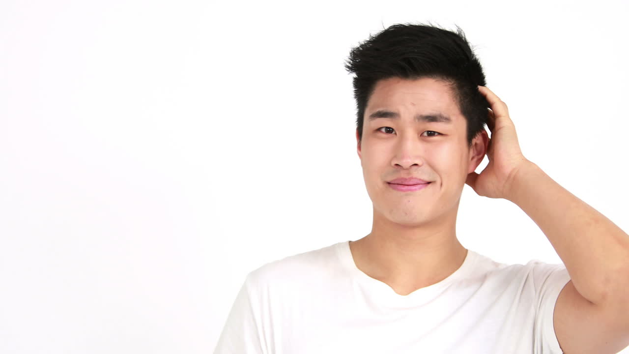 미소 짓는 남자가 머리를 고 카메라를 쳐다보고 있다