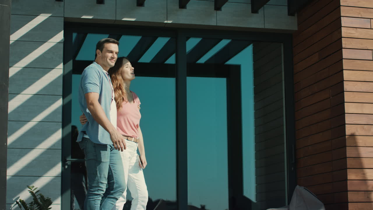 편안한 남자와 여자가 럭셔리 집 밖에서 머물고 있습니다.