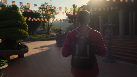 hombre caminando por un templo budista al amanecer