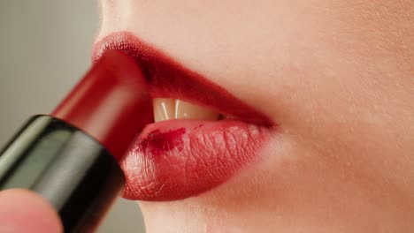 mujer aplicar lápiz labial rojo