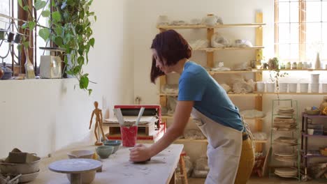 Young-female-potter-working-in-her-studio