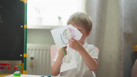 Diligent-boy-cuts-out-circle-with-drawing-of-copybook-page