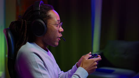 a man playing video games with headphones and a controller