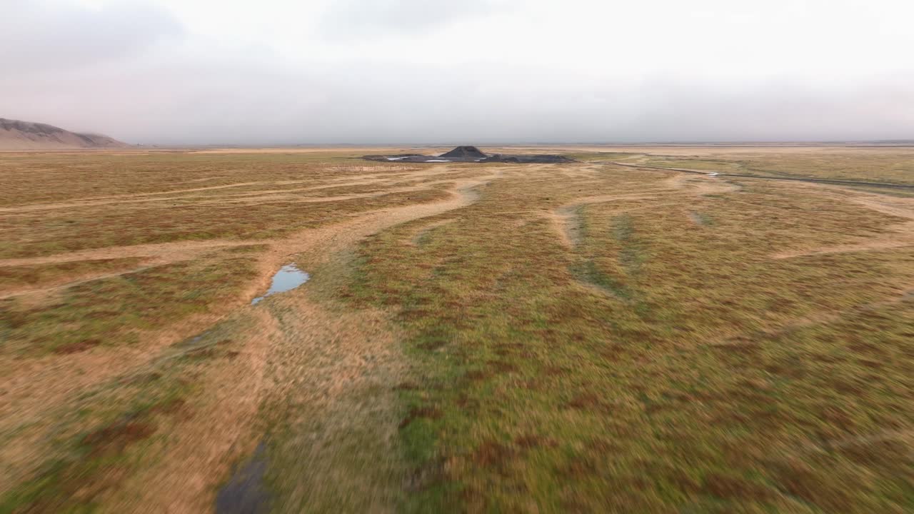 tomada de un avión no tripulado de un montículo volcánico aislado rodeado de llanuras herbáceas cerca de mt.