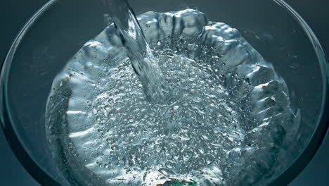 sparkling aqua pouring glass top view closeup. mineral drink filling glassware