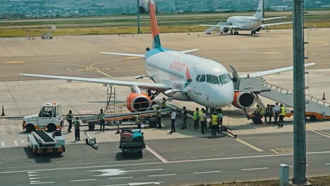 airplane at the airport: passengers boarding and ground crew activities