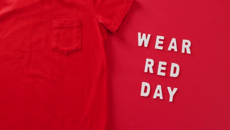 video of close up of wear red day text and red tshirt on red background