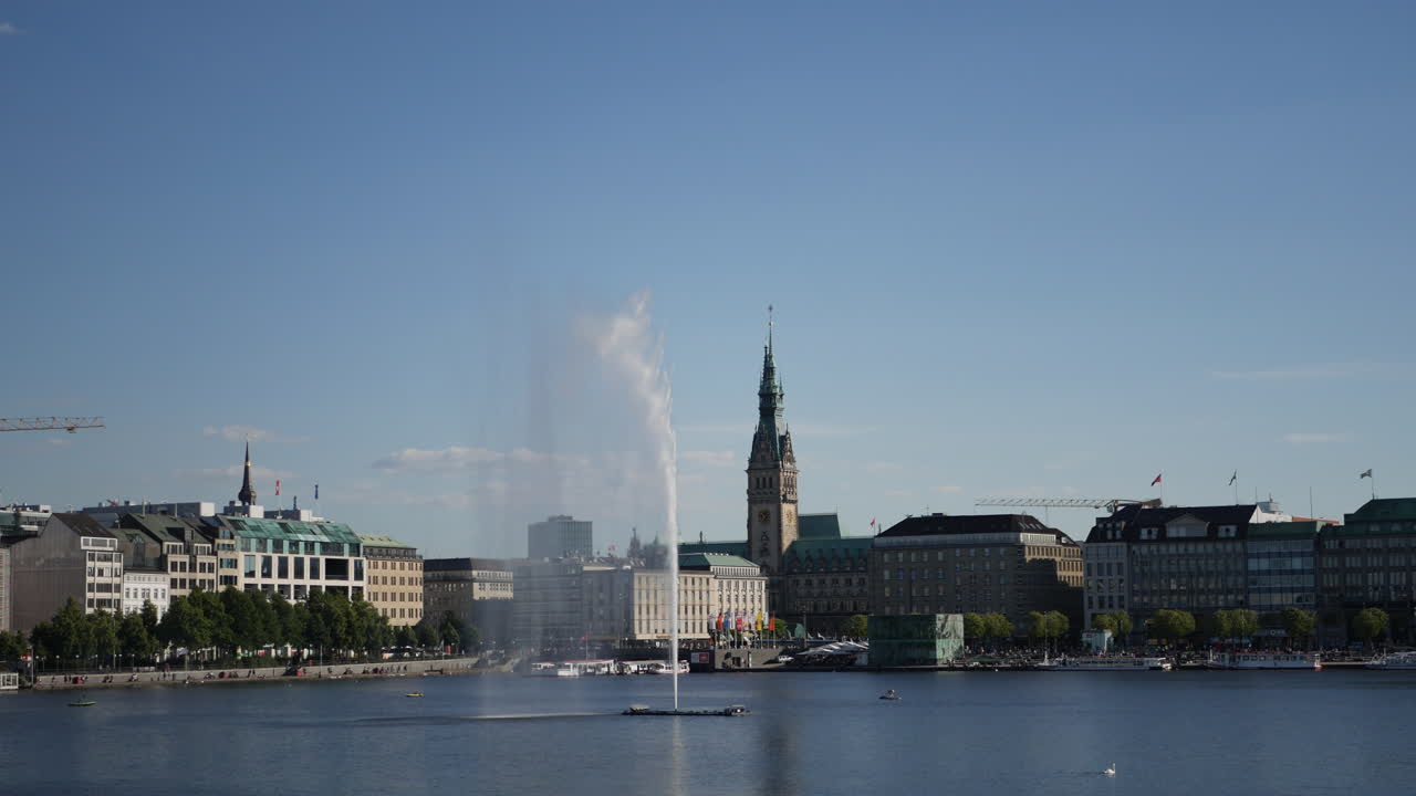 People enjoy rowing and paddling at binnenalter lake in Hamburg, Germany at sunny day. Alster fountain and swanin the picture.