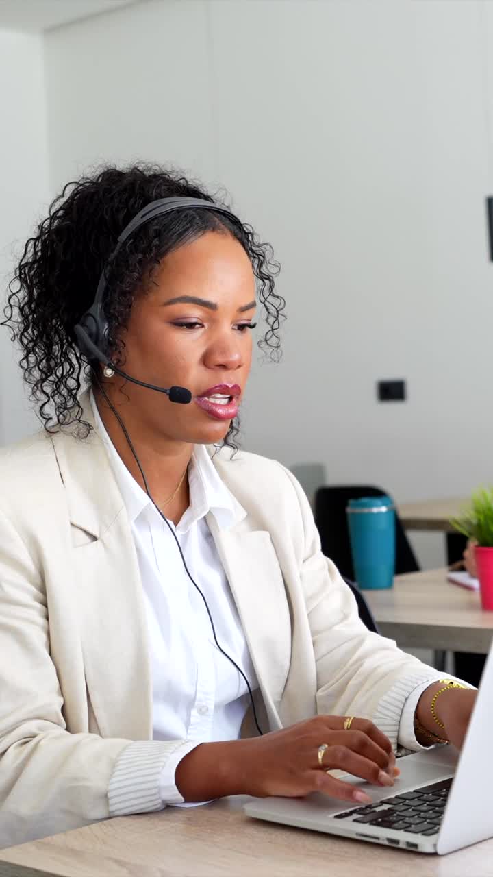 Businesswoman working at her computer with a headset on in the office